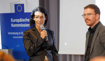 Judit Hercegfalvi hält begrüßende Worte auf der Bühne.