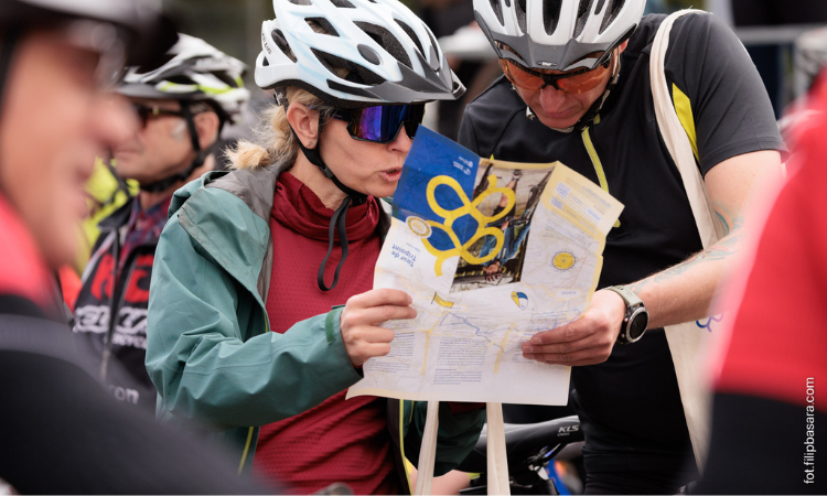Zwei teilnehmende Radafahrende studieren eine gedruckte Karte der Tour de Tripoint. 
