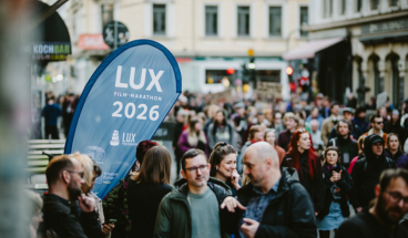 Vor dem Kino zieht eine Demonstration zum Frauentag vorbei. Am Eingang des Kinos weht die LUX-Flagge.
