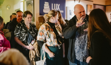 Gehörlose und hörende Personen kommen im Foyer ins Gespräch nach dem Film und dem Film-Talk.