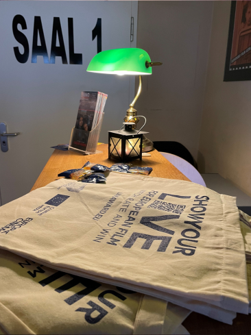 Abstimmungs-QR-Codes auf Taschen liegen vor dem Eingang des Kinosaals aus.